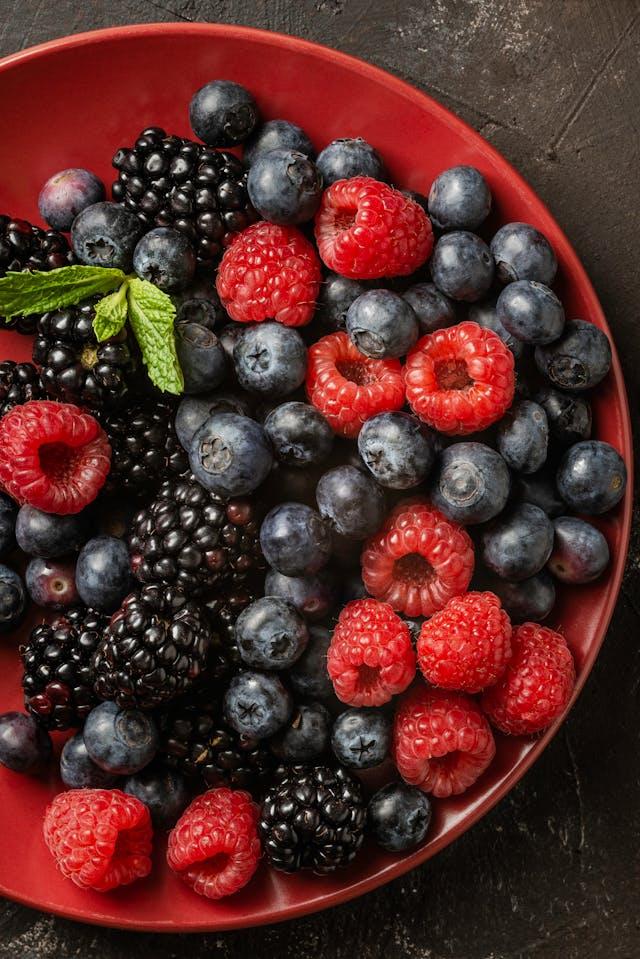 Coupelle rouge avec des myrtilles, framboises et cassis